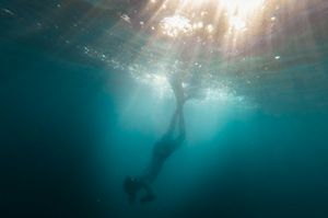 "Deep in the sea: underwater photo of person diving"