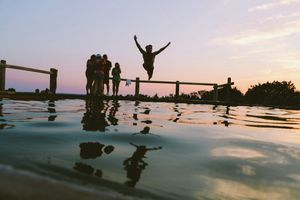 "Jumping into the pool: man jump in mid air on body of water"